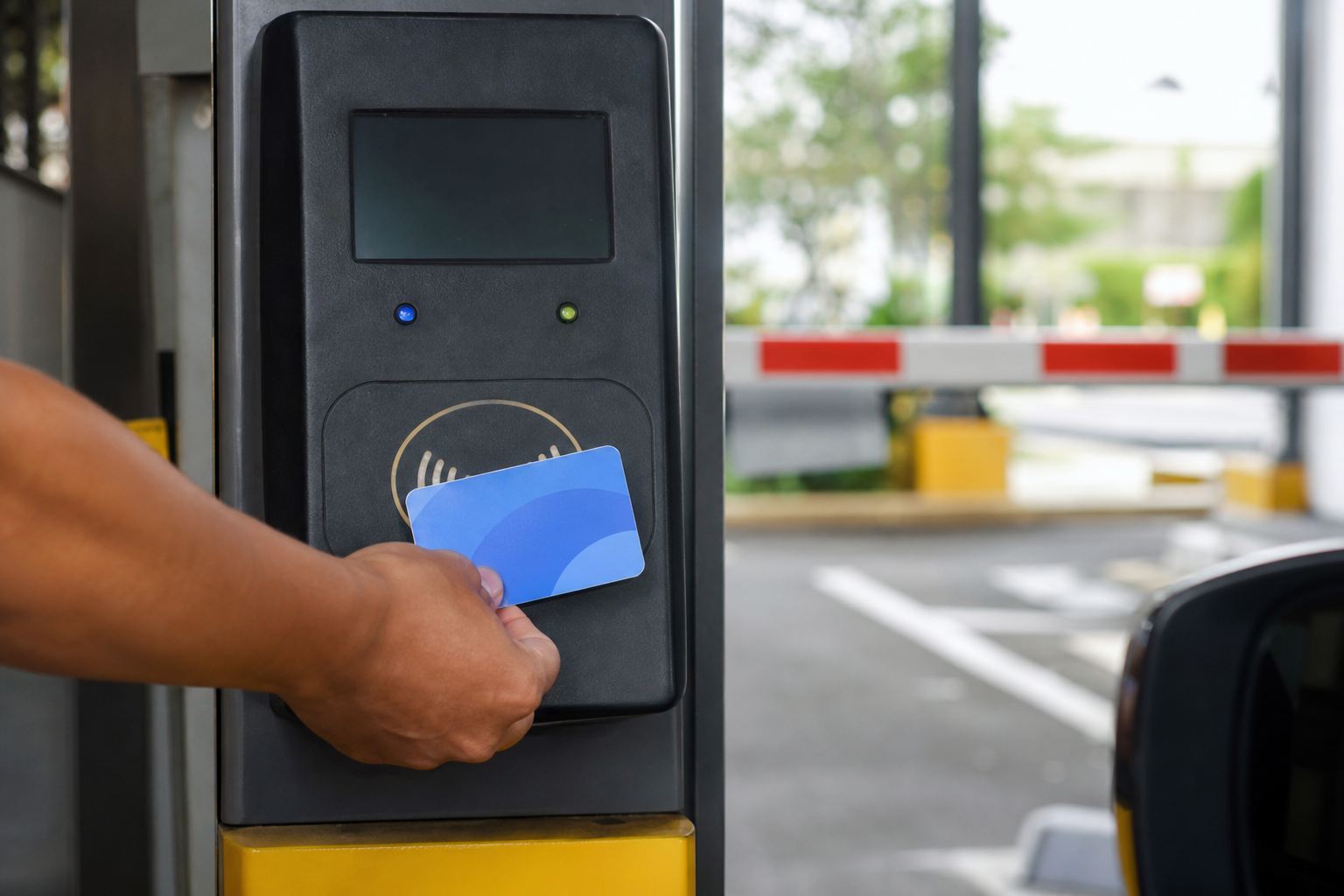 Tangan menempelkan kartu uang elektronik di pembaca gerbang parkir