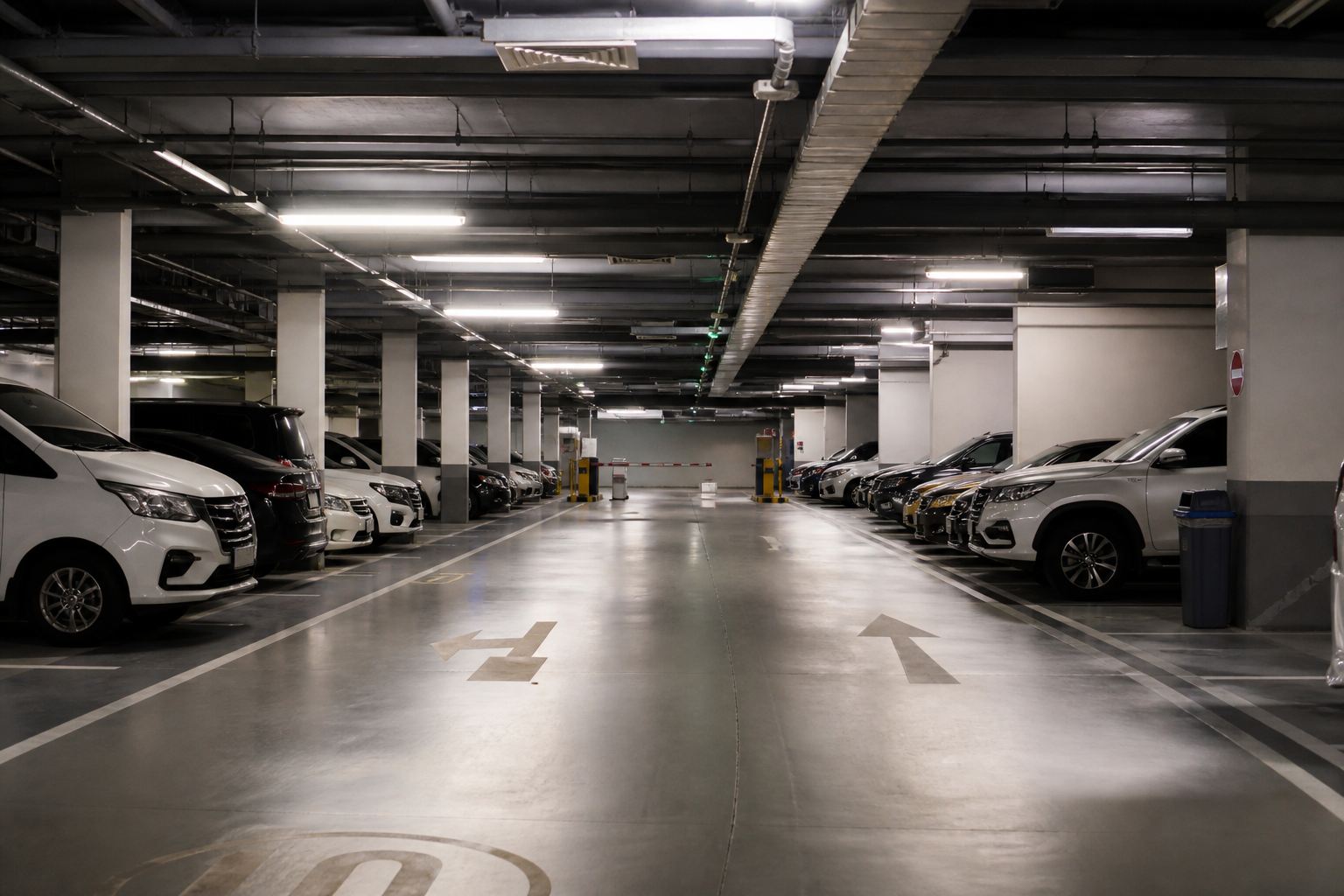 Basement parkir hotel yang rapi dengan palang di ujung lorong