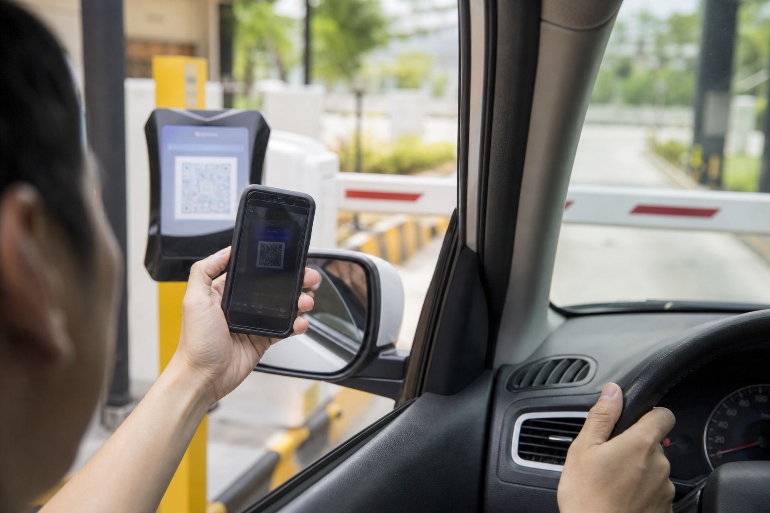 Pengemudi membayar parkir di gerbang keluar dengan memindai kode QR di ponsel
